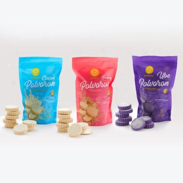 Goldilocks Polvoron in Classic, Pinipig, and Ube flavors, with cookies stacked beside each colorful bag.