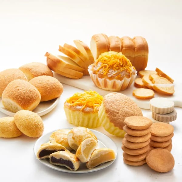 Assortment of Filipino baked goods, including pandesal, mamon, ensaymada, and various cookies.