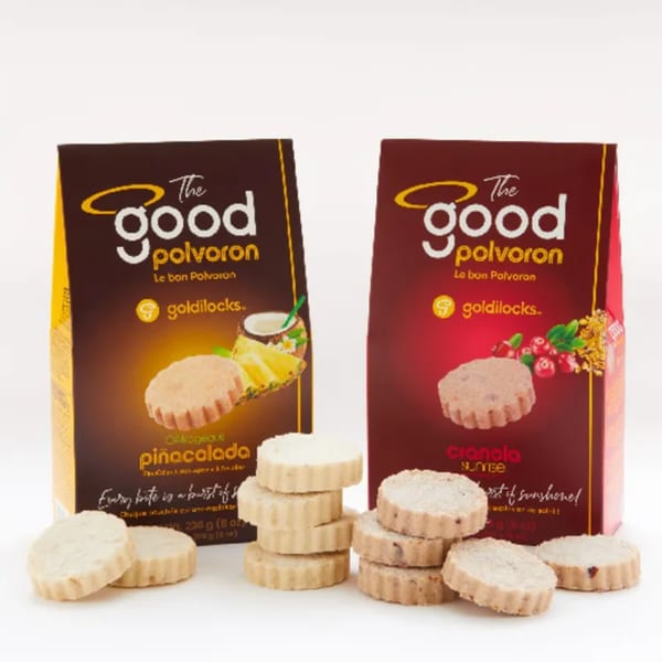 Two Goldilocks Polvoron boxes, Piñacalada and Cranola Sunrise, with stacks of their respective shortbread cookies.